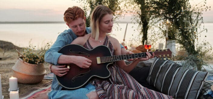 A man teaching how to play guitar