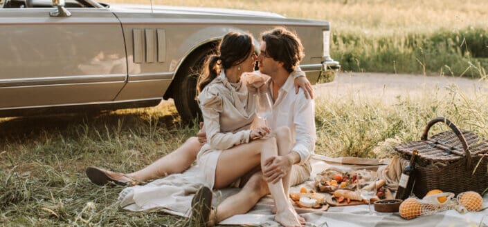 romantic couple sitting on a grassy field