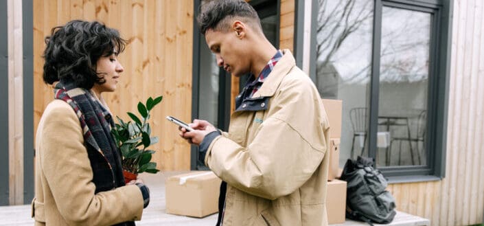 A woman looking at the man using mobile phone