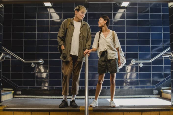 Asian couple standing near railing in underground passage