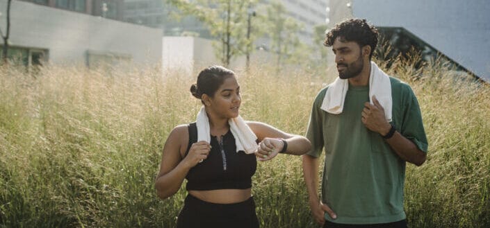 Athletic couple talking in field of grass