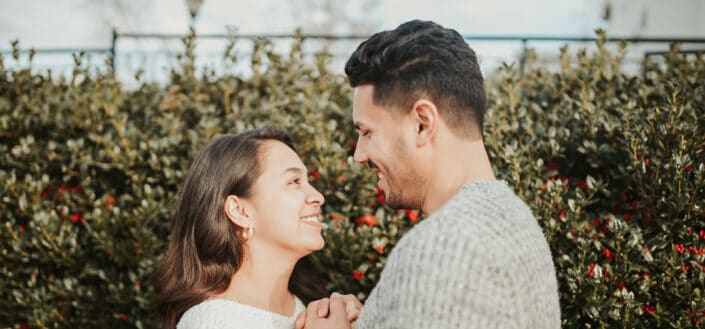 Couple standing in street near green plants