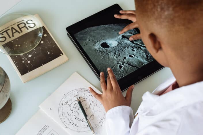 Student studying craters of moon on tablet