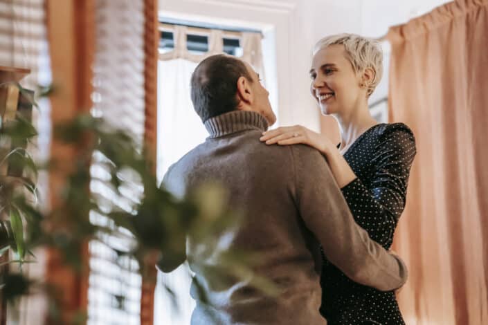 couple looking at each other while dancing in apartment