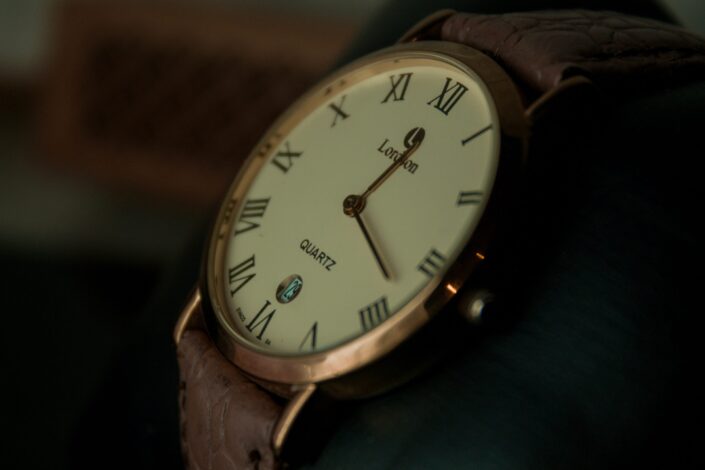 a gold watch with a brown leather strap