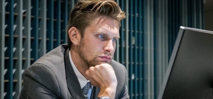 Male Receptionist looking at his Computer while posing for the Camera.