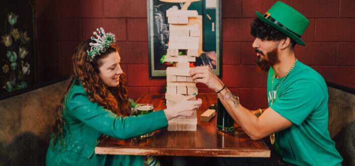 Man and a woman playing jenga inside a pub