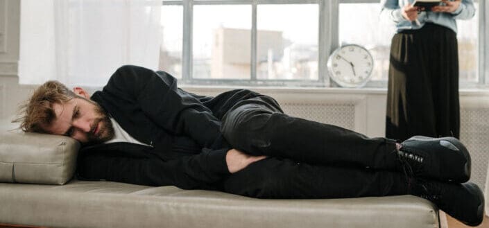 Man in black jacket lying on bed