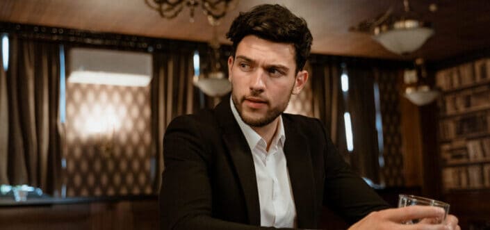 Man in black suit jacket sitting at the bar counter