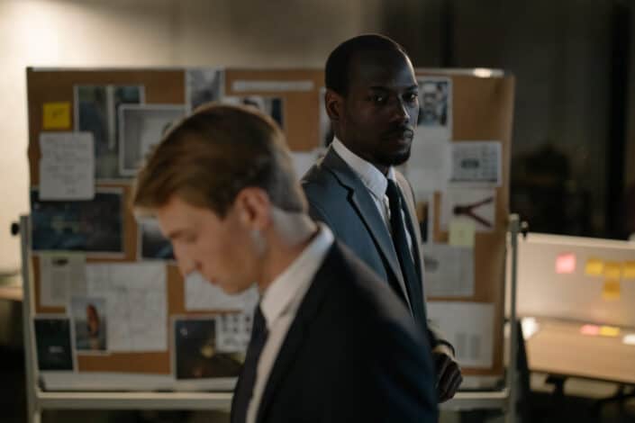 Man in black suit standing beside another man