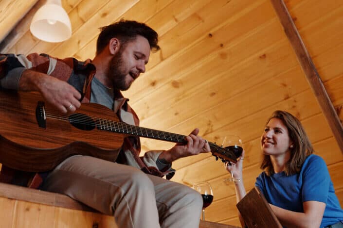 Man playing guitar next to the smiling woman