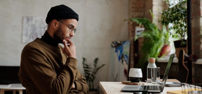 Man thinking while looking at laptop