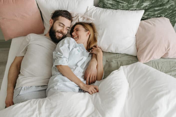 Overhead shot of a couple smiling on a bed