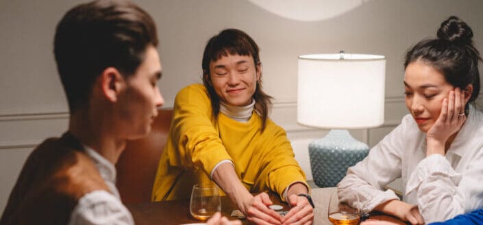 People playing poker on wooden table