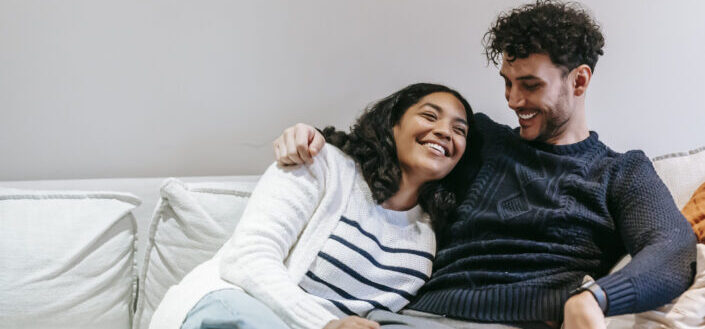 Happy couple cuddling on couch