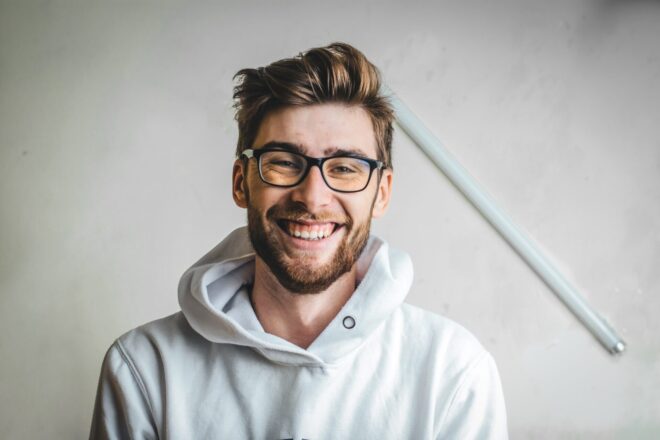 Short Beard Styles - Smiling guy with a black reading eyeglasses wearing a white hoody