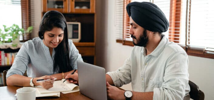 Smiling spouses discussing business plan at home