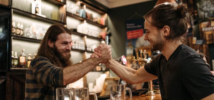 Two men arm wrestling in the bar