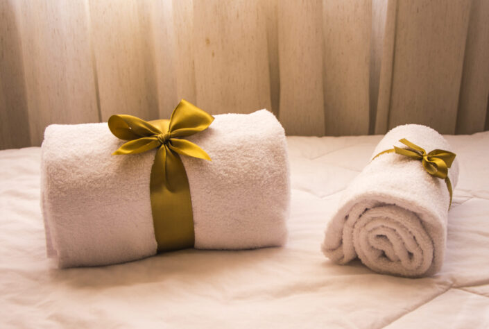 Two white towels with gold ribbon