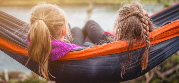 two women lying on hammock