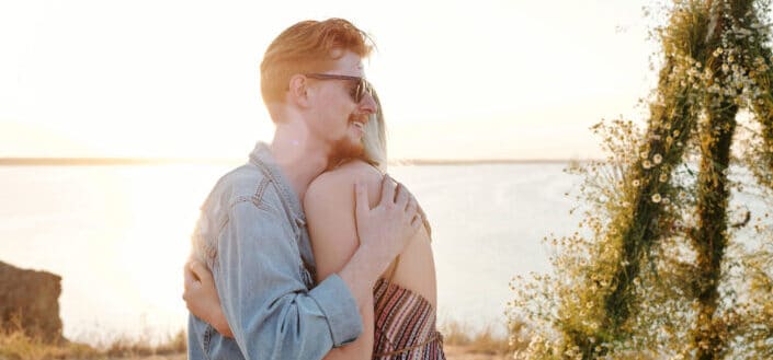 A couple hugging on the beach shore