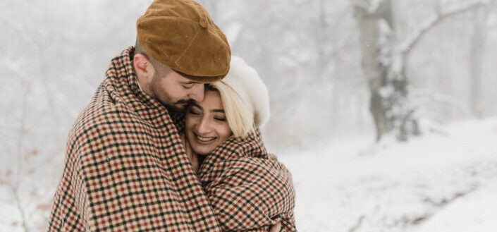 A couple hugging under the snow