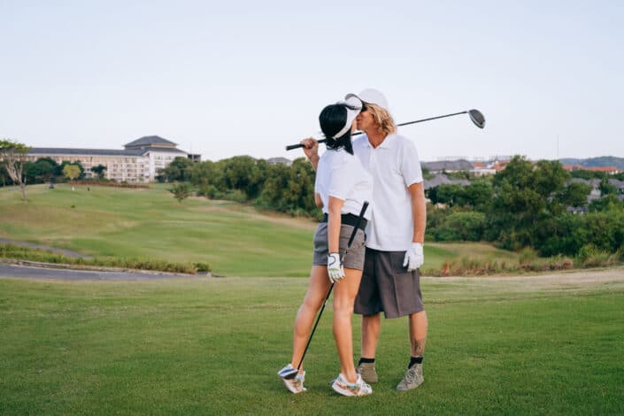Man and woman kissing on golf course