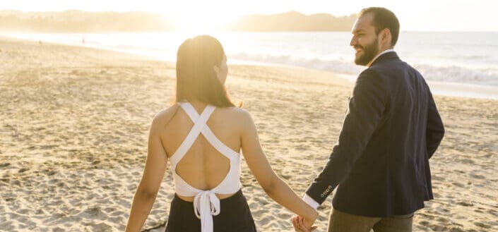 Couple walking on the sand during sunset