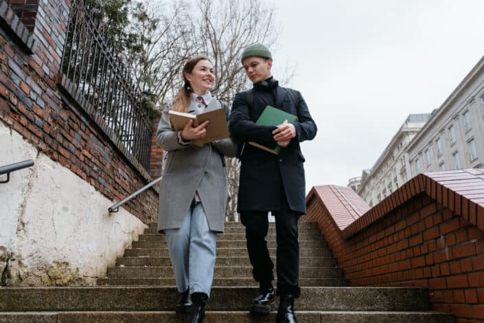 A man and woman walking down the stairs while having conversation