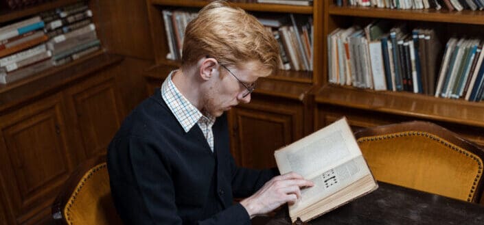 A man reading a book inside library