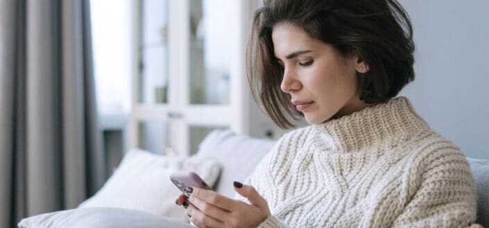 A woman in sweater using a cellphone