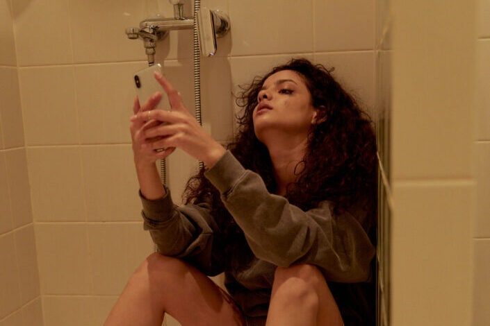A woman sitting on the bathroom floor