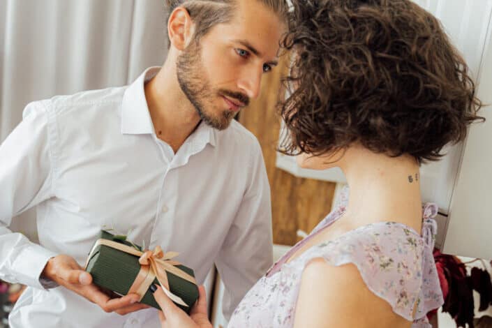 Bearded man giving gift to a woman