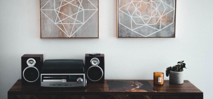 Black shelf stereo on brown wooden sideboard