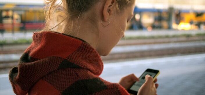 Woman in hoodie looking at her phone