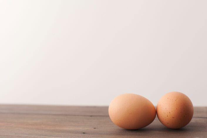 Two brown eggs laid on a table