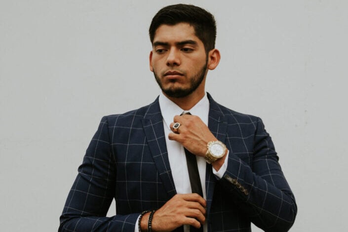 Confident male entrepreneur adjusting tie