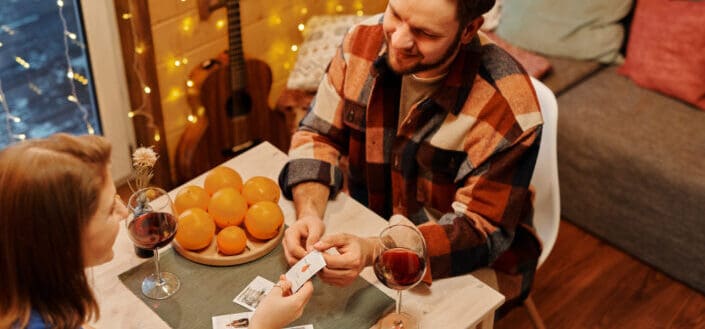 Couple playing cards during wine night