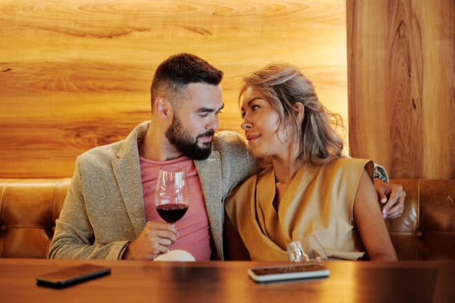Couple sitting close together while drinking wine - Cool Date Ideas