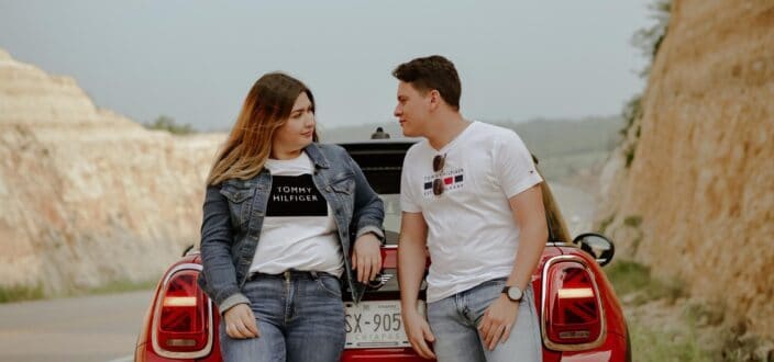 Couple Sitting on a Red Car