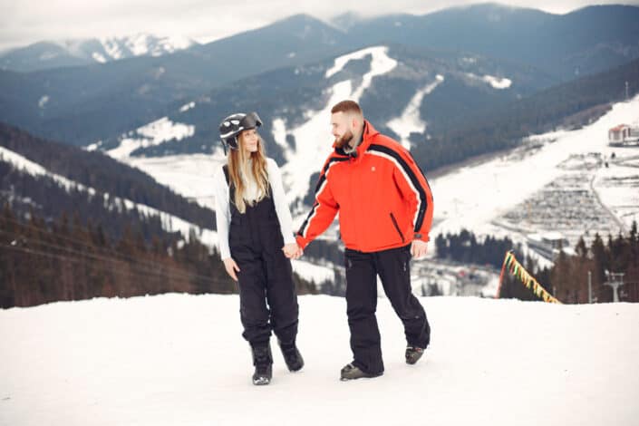 Couple with skiing equipment holding hands