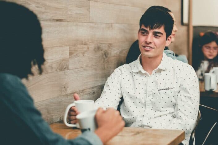 Two guys talking in a coffee shop 