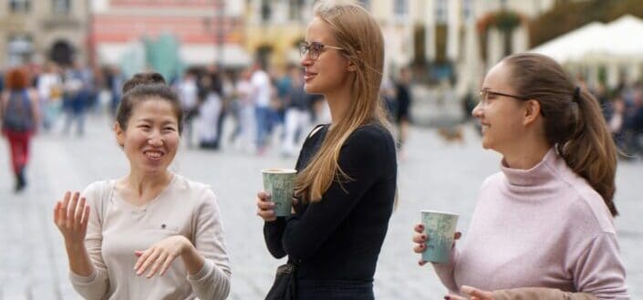three happy women while holding a cup of coffee