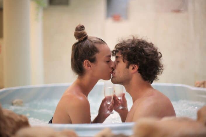 Happy couple kissing in their bath tub