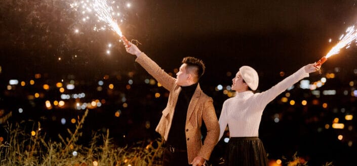 Happy couple with fireworks at night