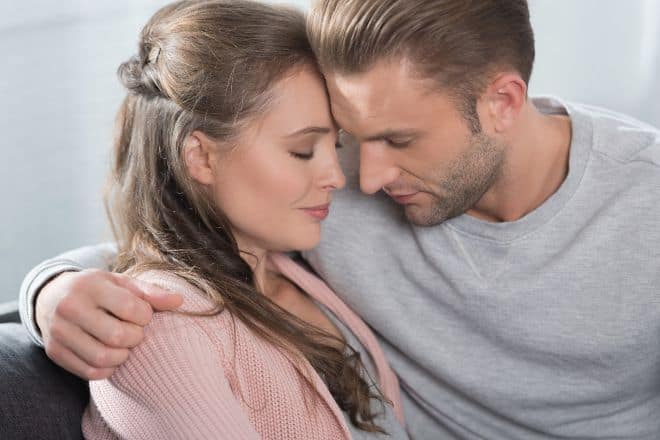 Couple going to kiss while sitting on sofa - How to Get a Girl to Like You Again