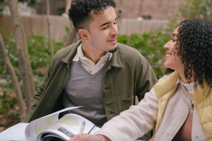 Young couple studying together outside