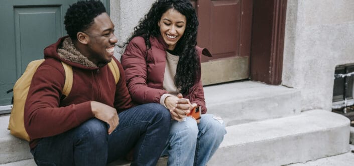 couple laughing and holding hands on stairs