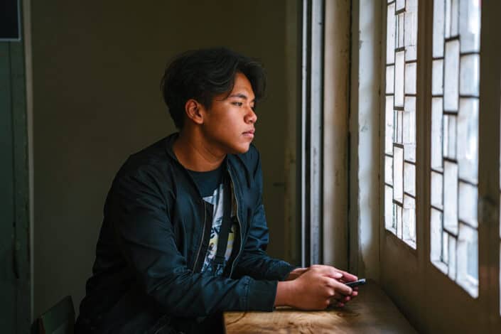 Man beside window wearing black jacket