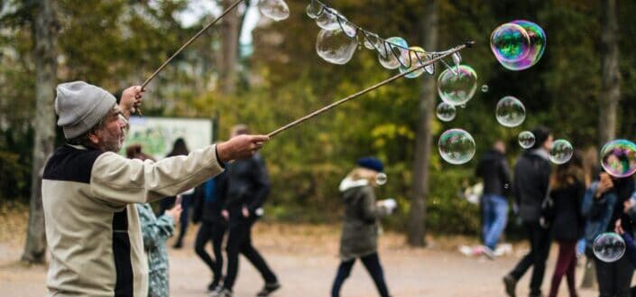man holding stick while making bubbles